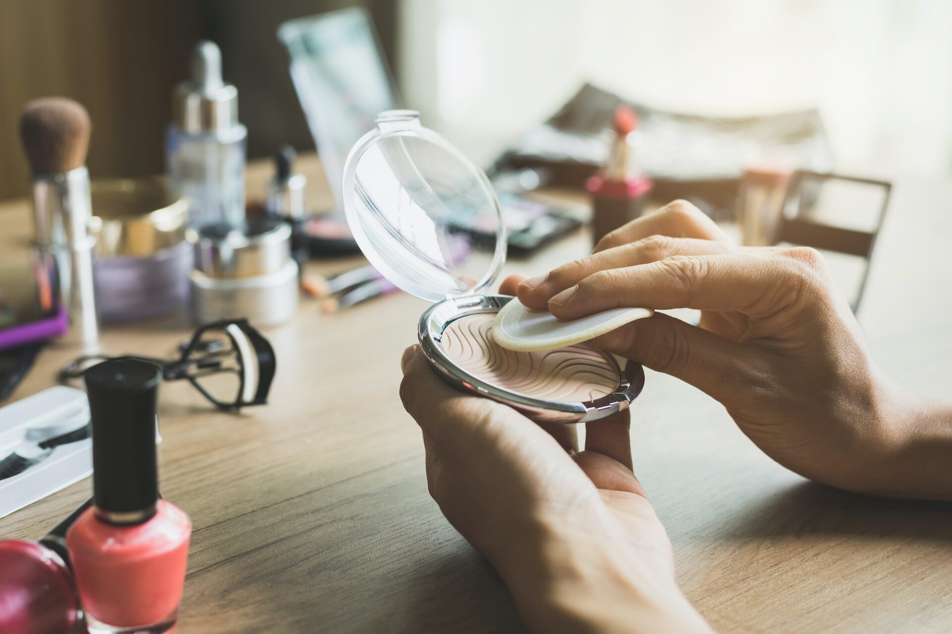Girl doing makeup on dressing table with cosmetics Girl doing makeup on dressing table with cosmetics